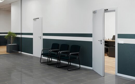 En cas d'alarme, les personnes quittent un immeuble de bureaux par une porte de sortie de secours.