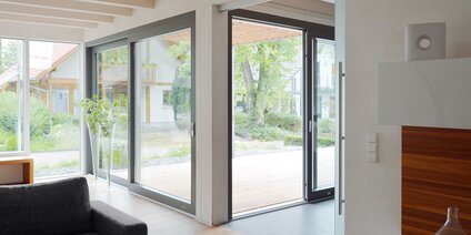 Espace de vie généreux avec porte levante-coulissante et terrasse en bois moderne à l'extérieur
