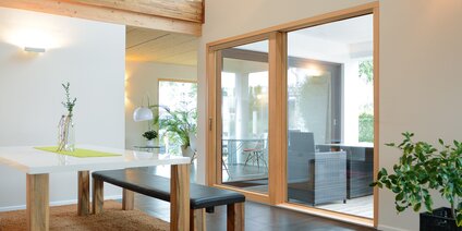 Intérieur moderne avec table à manger et vantail soulevant-coulissant avec vitrage panoramique