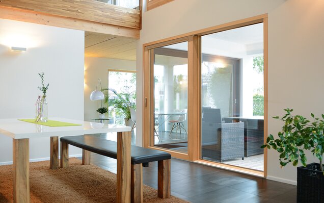 Intérieur moderne avec table à manger et vantail soulevant-coulissant avec vitrage panoramique