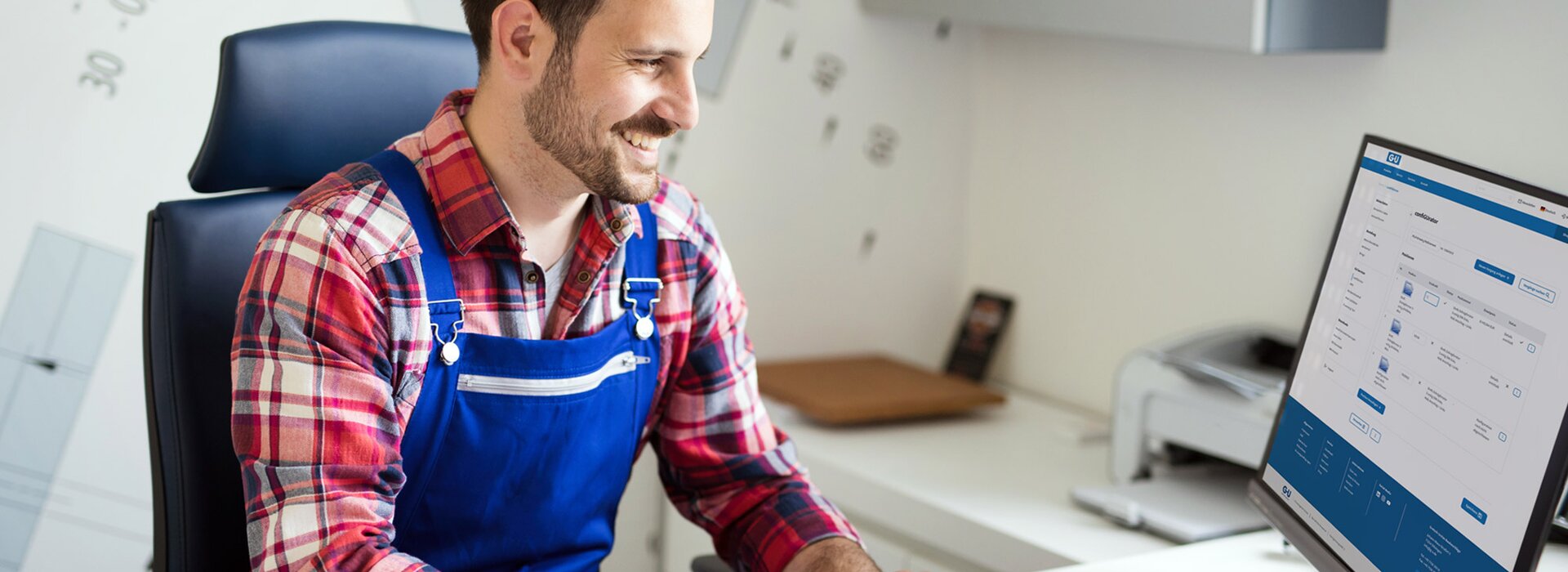 Un technicien en tenue de travail réalise une configuration de produit sur l’ordinateur avec le confiGUrator.