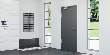 Hall d'entrée moderne d'un immeuble résidentiel avec porte d'entrée à un vantail, fermée, équipée d'un ferme-porte OTS 633 N