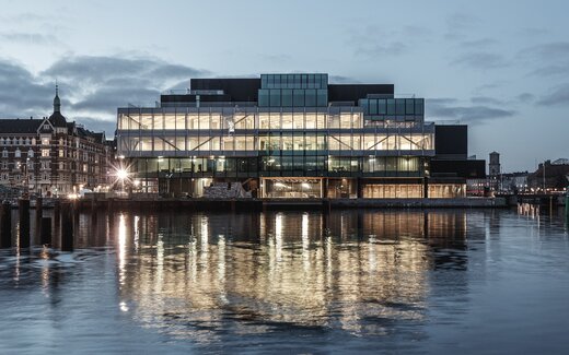 Bâtiment moderne avec façade en verre le soir