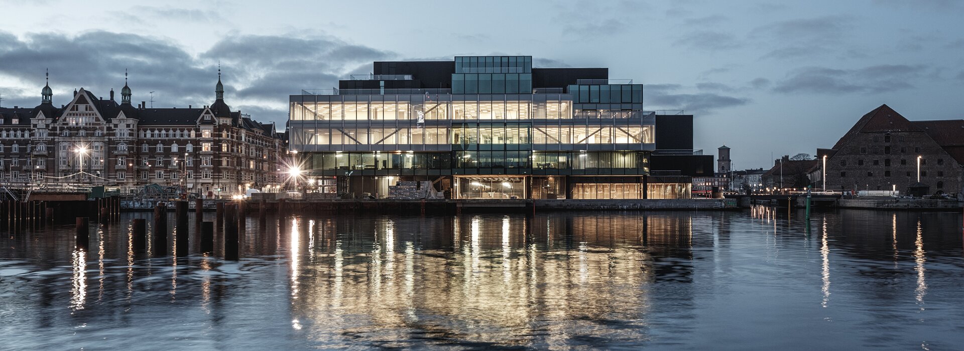 Bâtiment moderne avec façade en verre le soir
