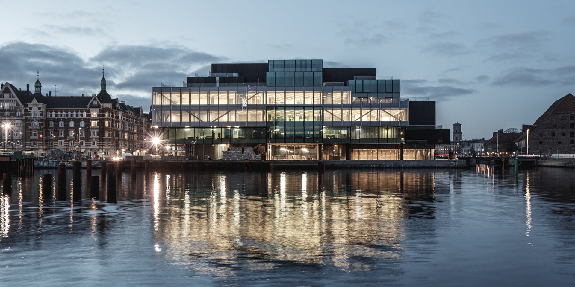 Bâtiment moderne avec façade en verre le soir
