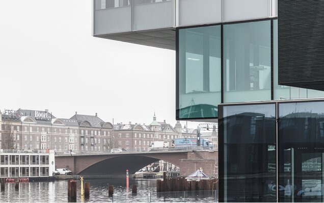 façade en verre avec passerelle et bâtiment ancien