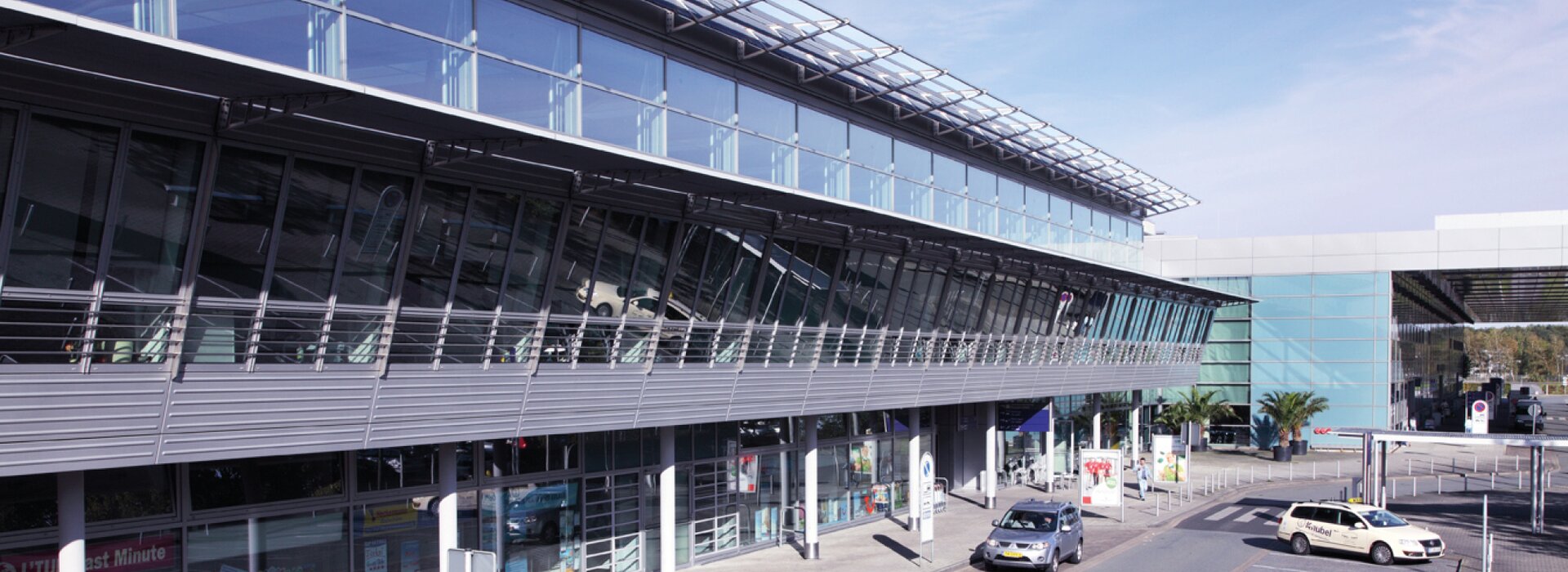 terminal d'aéroport avec parkings et voitures