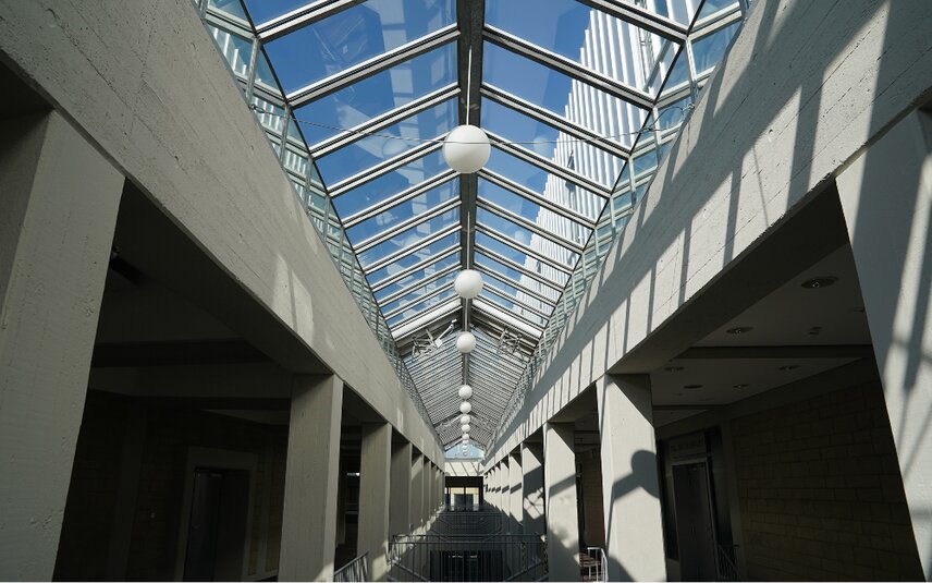 Couloir de bâtiment bien éclairé avec toit en verre
