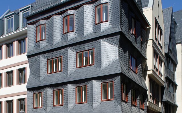 façade avec des panneaux d’ardoise et des fenêtres en bois