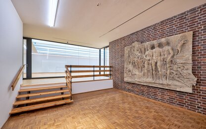 galerie avec escalier en bois et relief mural