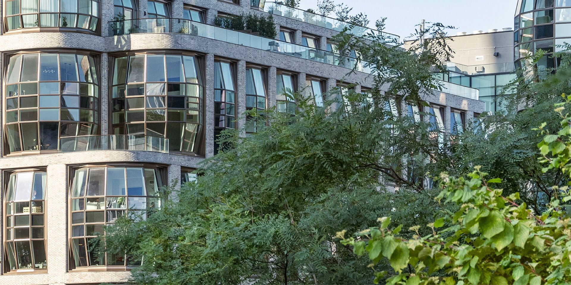 bâtiment avec façade vitrée et avant-plan vert