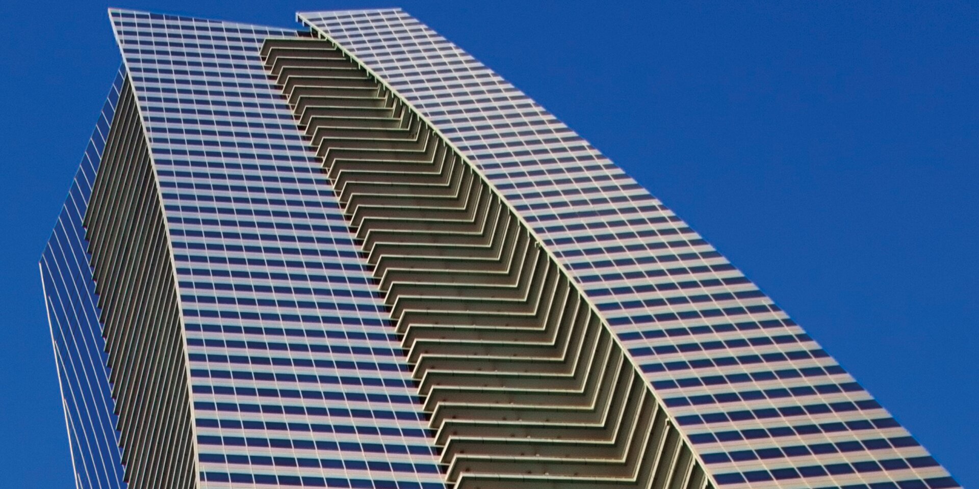 Immeuble de grande hauteur avec façade en verre et ciel bleu