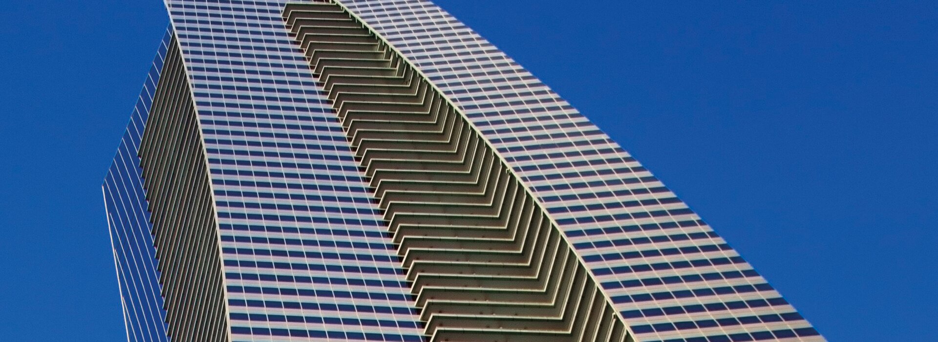 Immeuble de grande hauteur avec façade en verre et ciel bleu