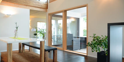 Espace repas avec vantail soulevant-coulissant avec vitrage panoramique Intérieur moderne avec table à manger et vantail soulevant-coulissant avec vitrage panoramique