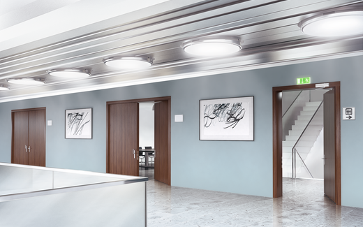 Zone de couloir d’immeuble de bureaux – porte en bois à un vantail comme porte de sortie de secours – avec ferme-porte en applique OTS 430 – porte ouverte